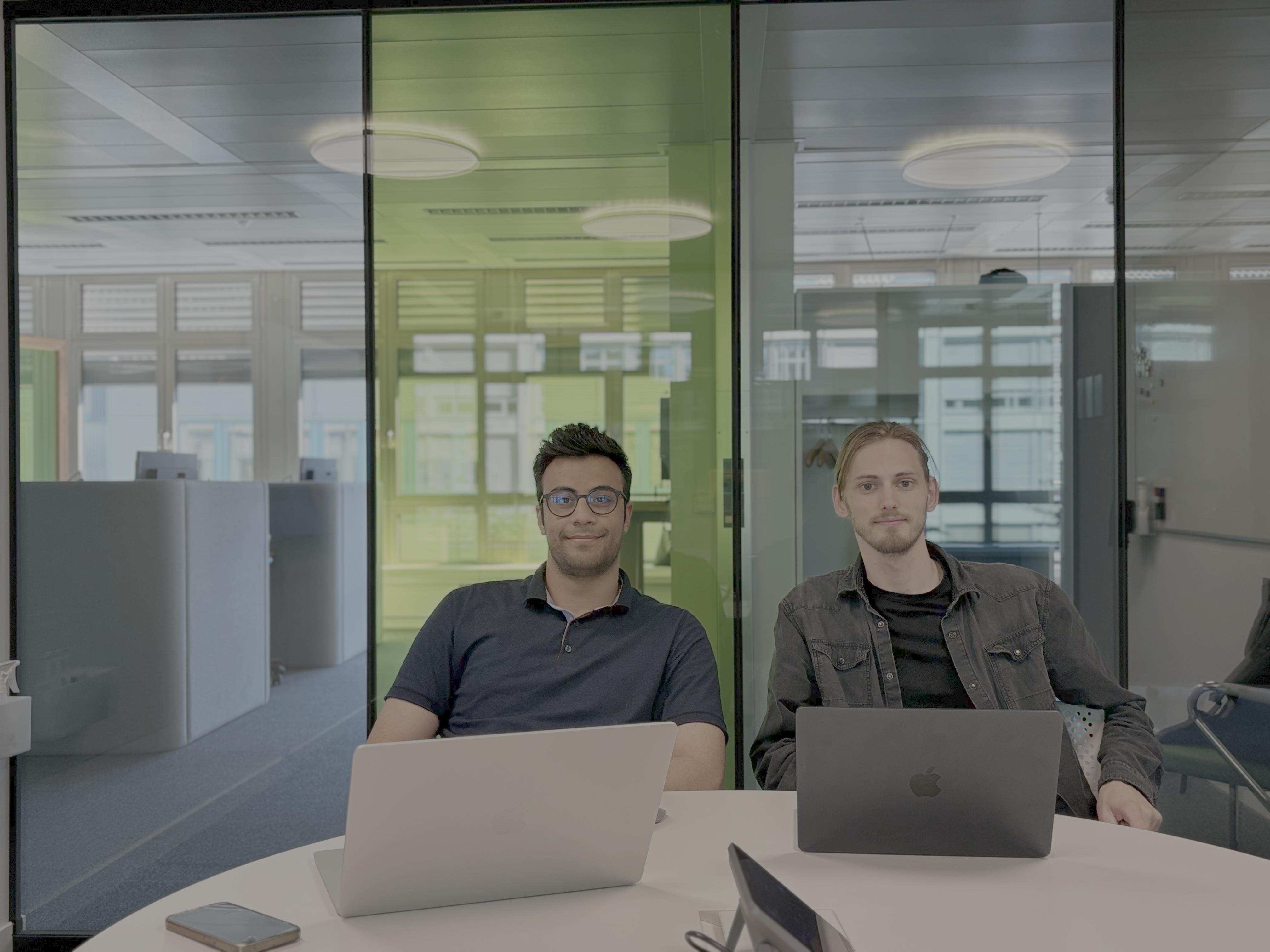 two professional tech entrepreneurs standing in a modern minimalist office with glass walls, soft cinematic lighting, looking focused